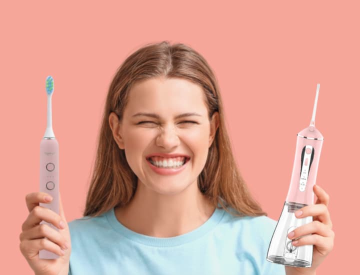 Femme présentant un kit complet d'hygiène bucco-dentaire : brosse à dents électrique et jet dentaire hydropulseur roses.